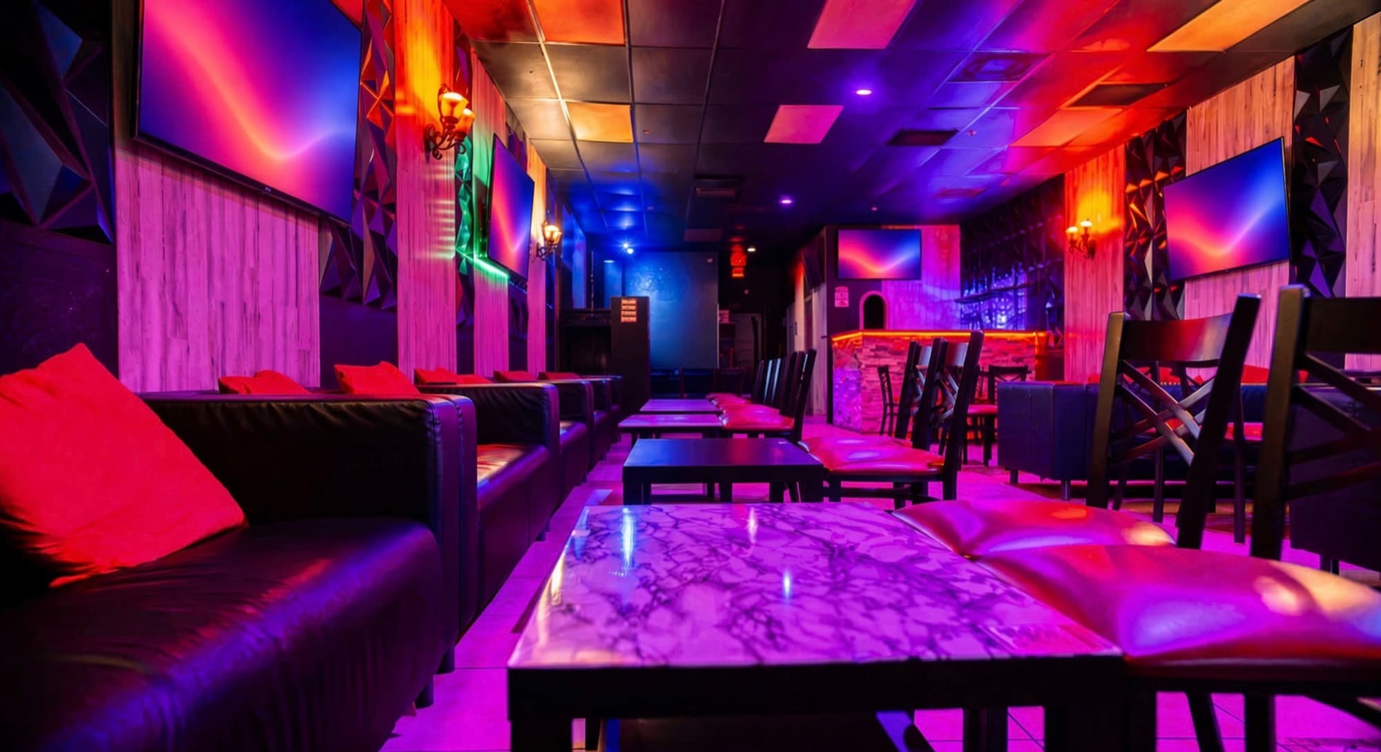 Purple-lit leather sofas and marble tables along the lounge wall