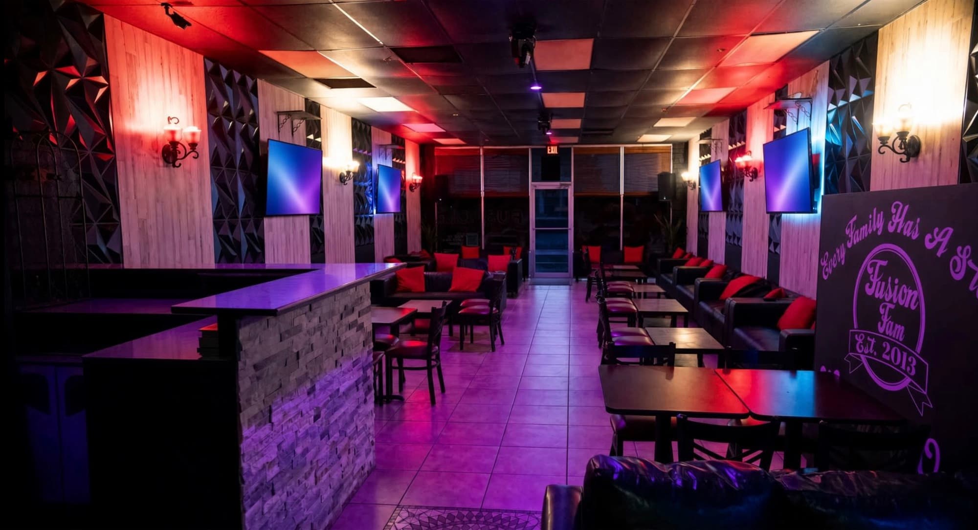 Stone-front bar and lounge seating with the Fusion Fam sign on the right